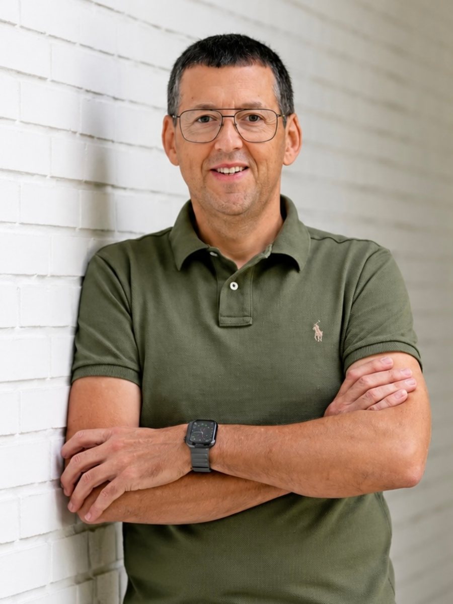 Markus Knauth, Jugendcoach, lehnt mit verschränkten Armen an einer weißen Backsteinwand